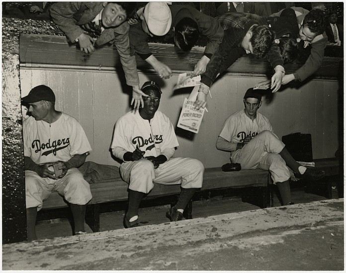Unidentified photographer, Jackie Robinson signing autographs, c. April 11, 1947
Vintage gelatin silver print, 6 1/2 x 8 1/4 in. (16.5 x 21 cm)
Later identification labels "Jackie Robinson on The Dodgers' bench early in the 1947 season. Coach Ray Blades is on the left, pitcher Ralph Branca on the right." on print verso.
8478